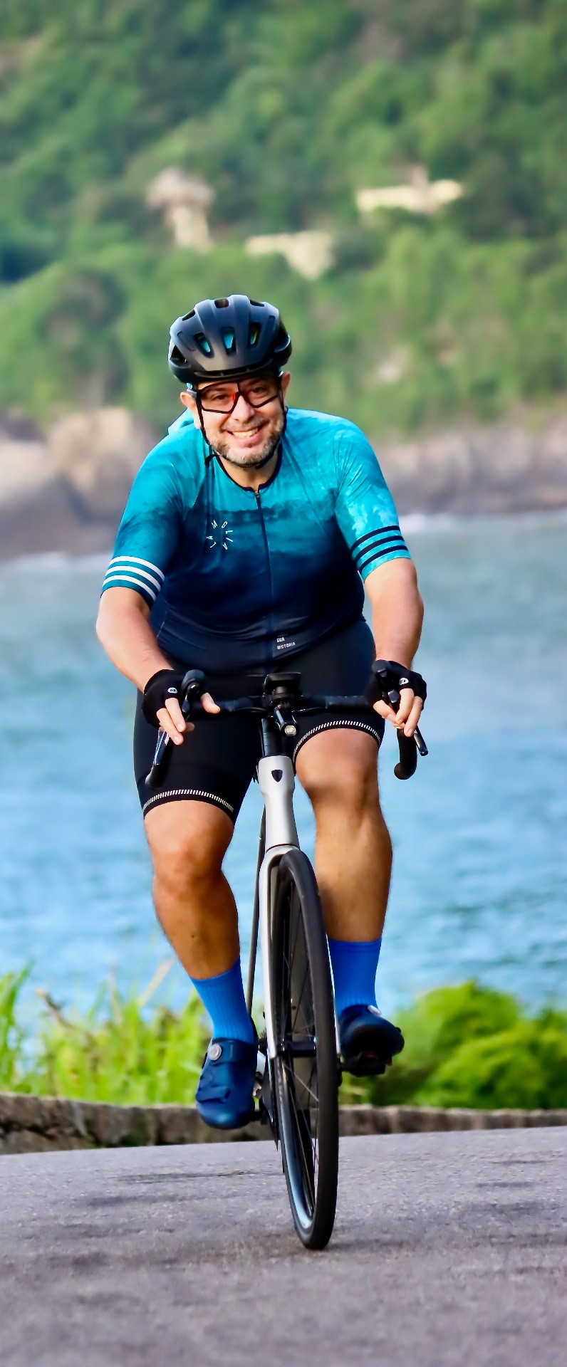 Fabio Pupo pedalando em trajeto costeiro sorrindo